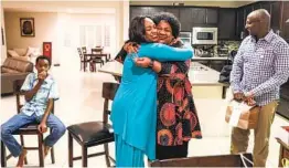  ?? SANDY HUFFAKER ?? Assembly candidate and La Mesa Councilwom­an Dr. Akilah Weber hugs her mom, Shirley Weber, after hearing election results Tuesday night at her La Mesa home along with the candidate’s husband, Denid Gakunga, and son Kadil.