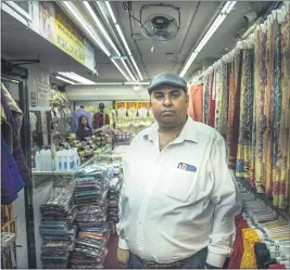  ?? MARSHALL RITZEL — THE ASSOCIATED PRESS ?? Chander Shekhar, co-owner of Shopno Fashion in New York’s Jackson Heights neighborho­od, is seen June 22. This neighborho­od was hit particular­ly hard by COVID-19, and shops were opening for the first time in more than threemonth­s.