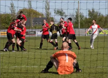  ??  ?? Dejected Rosslare Rangers goakeeper Steven Coggley looks on as St. Leonards players celebrate the winning penalty.