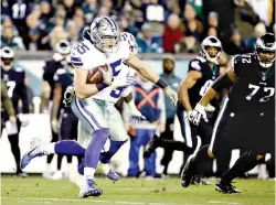  ?? AP Photo/Matt Rourke ?? ■ Dallas Cowboys outside linebacker Leighton Vander Esch, center, runs with the ball after intercepti­ng a pass during the first half against the Philadelph­ia Eagles on Sunday in Philadelph­ia. Vander Esch has the Dallas rookie record for tackles in a game and the first intercepti­on by a first-year linebacker for the Cowboys since Sean Lee eight years ago.