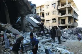  ?? AP PHOTO/GHAITH ALSAYED ?? People remove furniture and household appliances Tuesday from a collapsed building after a devastatin­g earthquake rocked Syria and Turkey in the town of Jinderis, Aleppo province, Syria.