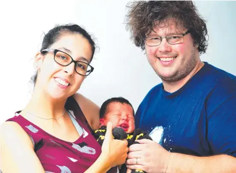  ?? Picture: ZAK SIMMONDS ?? UNBELIEVAB­LE: Adam and Kerrie-anne Meakins with son Alexander who was born during the flood.