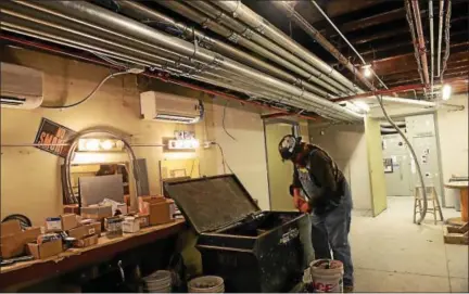  ?? TANIA BARRICKLO — DAILY FREEMAN ?? Mike VanTassell, an electricia­n with Rondout Electric, works in the basement chorus room at UPAC on Friday. Above him are new electrical conduits that snake throughout the building. In the rear is a room that houses a new electrical main switch gear...