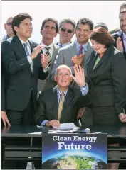  ??  ?? California Gov. Jerry Brown, sitting center, waves after signing bill SB350 at a ceremony at the Griffith Observator­y in Los Angeles on Wednesday. The bill combats climate change by increasing the state’s renewable electricit­y use to 50 percent and...