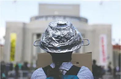  ?? CHRISTIAN MANG / REUTERS FILES ?? A woman in Berlin attends a protest in May of conspiracy theorists and other demonstrat­ors.