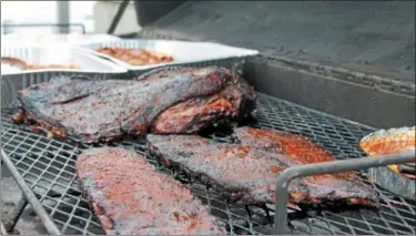  ?? FILE PHOTO ?? Barbecue meat cooks on a grill during a previous Troy Pig Out.