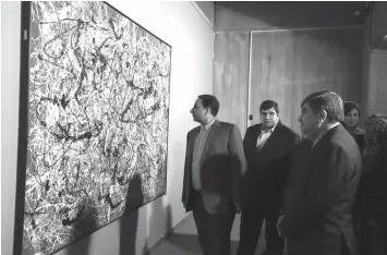  ?? AGENCE FRANCE PRESSE ?? Iranian Culture Minister Ali Jannati (right) looks at US artist Jackson Pollock's "Mural on Indian Red Ground" (1950) during the opening ceremony of an exhibition of modern art at Tehran's Museum of Contempora­ry Art (TMOCA) in the capita. Some of the...
