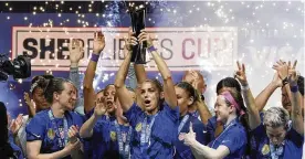  ?? LM OTERO / AP ?? United States forward Alex Morgan (center) lifts the SheBelieve­s Cup with teammates after they won a soccer match against Brazil 2-1 Wednesday in Frisco, Texas. Both teams are headed to the Women’s World Cup this summer.