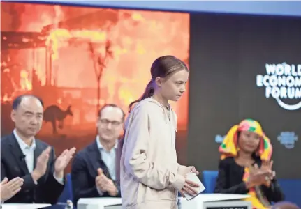  ?? MICHAEL PROBST/AP ?? Panel members applaud for environmen­tal activist Greta Thunberg after she addressed guests at the World Economic Forum in Davos, Switzerlan­d, on Tuesday. “My generation will not give up without a fight,” she said.