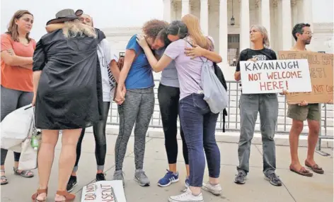  ??  ?? ►M●nifest●ntes se abrazan en una protesta contra Kavanaugh en la Corte Suprema, el martes, en Washington.