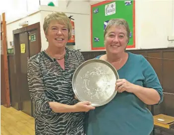  ??  ?? Shiskine SWI president Marilyn Woods, left, presents Julie Wilkinson with the Ferguson Plate for the member who received the most points during the season and the annual show.