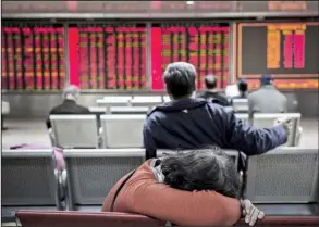  ?? Bloomberg News/QILAI SHEN ?? A woman rests at a securities brokerage in Beijing in this file photo. The general manager of China’s biggest stock brokerage and a prominent investor have been arrested on insider trading charges, the government said Friday.
