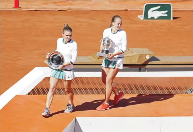  ?? — AP ?? PARIS: Latvia’s Jelena Ostapenko, right, holds the trophy after winning the women’s final match of the French Open tennis tournament against Romania’s Simona Halep, left holding the runner-up trophy, at the Roland Garros stadium, in Paris, France,...