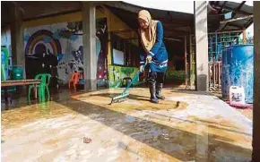  ?? NSTP PIC BY NIK ABDULLAH NIK OMAR ?? A teacher cleaning a preschool that was hit by floods in Tanah Merah, Kelantan, yesterday.