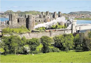  ?? ?? g Rolling back the years: the Tornado steam train passes Conwy Castle on the North Wales Coast Express route