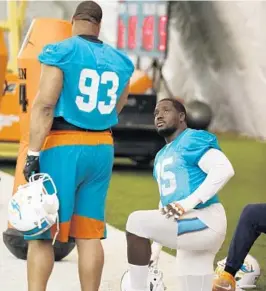  ?? WILFREDO LEE/AP ?? Miami defensive end William Hayes, right, talking with Ndamukong Suh, has establishe­d himself in the league as one of the best edge setting defensive ends.