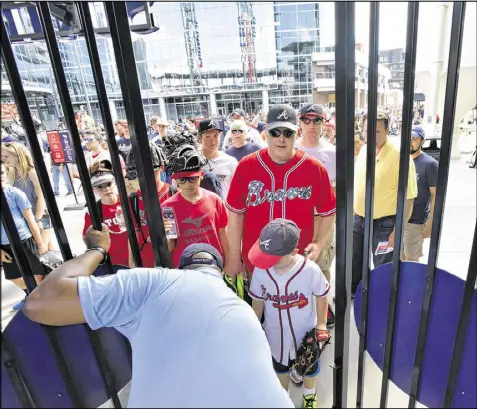  ?? HYOSUB SHIN / HSHIN@AJC.COM ?? As the gates open before the game against the Padres, fans are ready to file into SunTrust Park for its regular-season debut. The ballpark is the centerpiec­e of The Battery Atlanta, a mixed-use developmen­t.