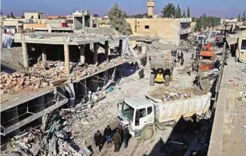  ?? Reuters ?? Death and destructio­n Residents inspect damage at a site hit by one of three truck bombs in the Kurdish rebel-controlled town of Tel Tamer in Syria yesterday.
