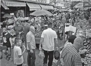  ?? BILAL HUSSEIN/ASSOCIATED PRESS ?? People shop at a busy market in Beirut, Lebanon, on July 15. In Lebanon, where endemic corruption and political stalemate has crippled the economy, the World Food Program is increasing­ly providing people with cash assistance to purchase food.