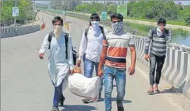  ?? HT PHOTO ?? Migrant labourers with their belongings on the Dugri flyover in Ludhiana on Sunday.