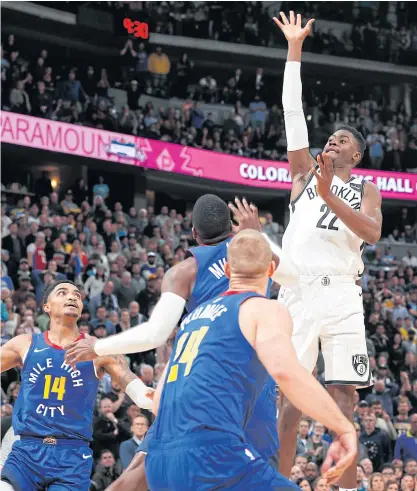  ??  ?? Nets guard Caris LeVert, right, floats over the Nuggets defence to hit the winning basket with 0.3 seconds left.