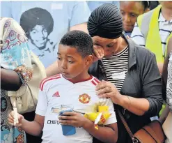  ??  ?? > Emotions run high as people attend a candlelit vigil outside Notting Hill Methodist Church near the 24-storey Grenfell Tower