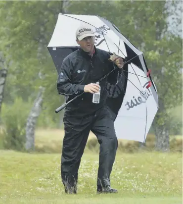  ??  ?? 0 Battling the elements in Aviemore, Michael Hoey grabs a sandwich during his opening-round 68.