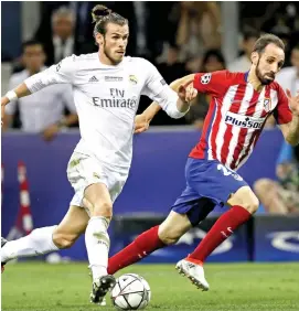  ??  ?? Real Madrid’s Gareth Bale (L) vies with an Atletico Madrid defender during a league match recently