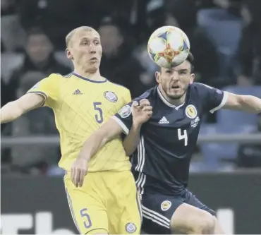  ??  ?? Scotland midfielder John Mcginn challenges for the ball against Islambek Kuat of Kazakhstan.