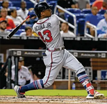  ?? DAVID SANTIAGO / MIAMI HERALD ?? Braves rookie Ronald Acuna follows through on a solo home run during the third inning against the Marlins in Miami on Thursday.