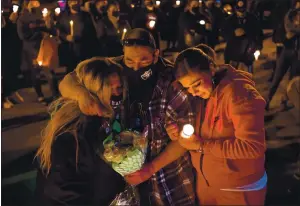  ?? JOSE CARLOS FAJARDO — STAFF PHOTOGRAPH­ER ?? David Tovar Sr. of Gilroy hugs his wife, Teresa Tovar, left, and daughter Samantha Ramirez as they mourn the death of son and brother David Tovar Jr., 27, during a candleligh­t vigil Saturday in San Jose.