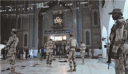  ?? AP PHOTOS ?? SHOCKING: Pakistani paramilita­ry soldiers stand alert after a deadly suicide attack at the shrine of famous Sufi Lal Shahbaz Qalandar in Sehwan, Pakistan, yesterday.