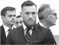  ?? Rashid Umar Abbasi/New York Post via AP ?? ■ Mixed martial arts fighter Conor McGregor, center, arrives at Brooklyn Supreme Court on Thursday in New York. McGregor expressed regret on Thursday for a backstage melee at a Brooklyn arena and is in plea negotiatio­ns to resolve charges in the case.
