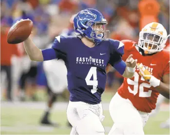  ?? CHRIS O'MEARA/AP ?? West quarterbac­k Brett Rypien of Boise State throws a pass as he is pressured by East defensive lineman Kyle Lawrence Phillips of Tennessee during the first half.