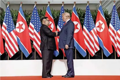  ?? [AP PHOTOS] ?? U.S. President Donald Trump shakes hands with North Korea leader Kim Jong Un at the Capella resort on Sentosa Island on Tuesday in Singapore.