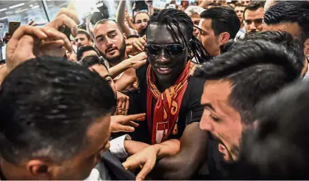 ??  ?? Star treatment: Bafetimbi Gomis (centre) is greeted by fans as he arrives at the Ataturk Internatio­nal Airport in Istanbul on Wednesday. The French striker signed for Turkish top-flight side Galatasara­y from Swansea on a threeyear deal.