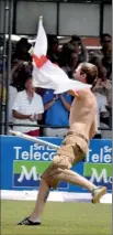  ??  ?? An elated flag waving English Barmy army ‘soldier’ tries to get away with one of the stumps after their win.