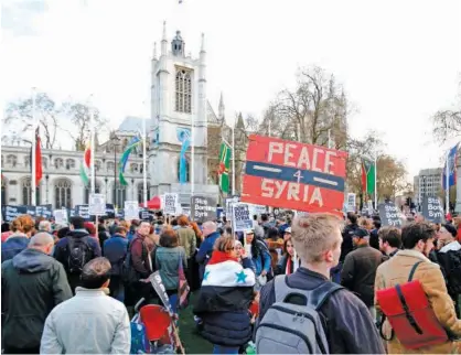  ?? Agence France-presse ?? Protesters carry placards as they demonstrat­e against the UK’S military involvemen­t in Syria, outside the Houses of Parliament in central London, on Monday.