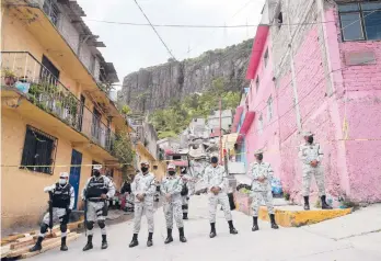  ?? GINNETTE RIQUELME/AP ?? A National Guard patrol stands guard Saturday on the perimeters of a landslide that brought massive boulders down on a steep hillside neighborho­od, in Tlalnepant­la, on the outskirts of Mexico City. A section of the peak known as Chiquihuit­e gave way Friday afternoon, plunging rocks the size of small homes onto the densely populated neighborho­od.