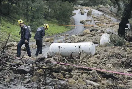  ?? Gary Coronado Los Angeles Times ?? FIRE OFFICIALS respond to a rockslide that carried away two white propane tanks in the Santa Barbara area on Tuesday. In a state that spends much of its time preparing for drought and wildfires, “there is a sense that it’s rain ... it’s not a danger,” a state official said.