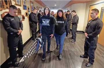  ?? LUIS SÁNCHEZ SATURNO/THE NEW MEXICAN ?? From left, Santa Fe police Officer Robert Duran’s son, Jaxon Duran, 15, and wife, Kayhleen Duran, enter the Law Enforcemen­t Academy after a memorial walk Thursday for Officer Duran, who died in the line of duty one year ago last week.