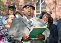  ?? STAFF PHOTO ?? Sherman Matthews, center, gathers with others on April 24, 2014, at a news conference at the Eastdale Village Community United Methodist Church.