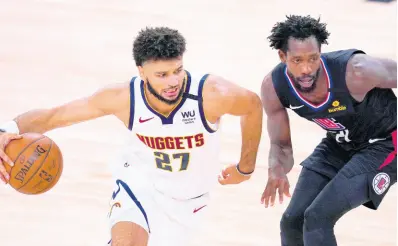  ?? MARK J. TERRILL ?? Denver Nuggets guard Jamal Murray (left) drives around Los Angeles Clippers guard Patrick Beverley during the first half of an NBA conference semi-final play-off on Tuesday in Lake Buena Vista, Florida. Denver won 104 - 89 and will face the LA Lakers in the Western Conference Finals, starting tomorrow.