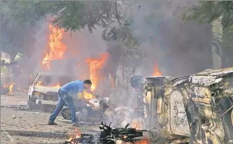  ?? AP PHOTO ?? A man lifts a motorbike in an area vandalised by Dera Sacha Sauda sect members in Panchkula on Friday.