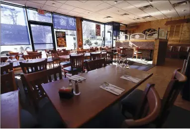  ?? AP PHOTO/CHRIS EHRMANN ?? In this March 11file photo, tables are empty at Eden Wok in New Rochelle, N.Y. The coronaviru­s pandemic gripping the nation is slamming the restaurant industry after years of steady growth amid the longest economic expansion in U.S. history. Restaurant­s and bars face a catastroph­ic loss of revenue that could destroy countless operations across that nation as customers stay home and practice “social distancing” to stem the spread of the virus.