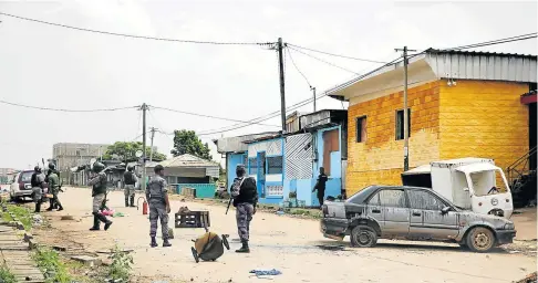  ?? Picture: STEVE JORDAN / AFP ?? CALM: Gabonese soldiers patrol in the streets near the headquarte­rs of the national broadcaste­r Radiodiffu­sion Television Gabonaise in Libreville after a foiled coup attempt by junior soldiers on Monday.