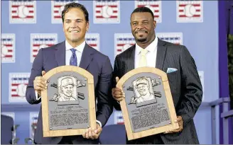  ?? MIKE GROLL / ASSOCIATED PRESS ?? New Hall of Famers Mike Piazza (left) and Ken Griffey Jr. display their plaques after their induction on Sunday in Cooperstow­n, New York.