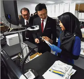  ??  ?? New technology: Chua being briefed by a Boston Scientific employee about the company’s medtech product as Batu Kawan MCA Division chairman Datuk Tan Lee Huat looks on.