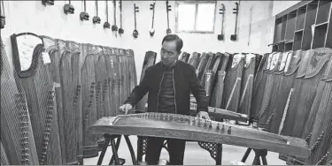  ?? ZHU XINGXIN / CHINA DAILY ?? In Xuchang village, a villager plays the guzheng at home.