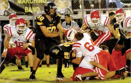  ?? MARK HUMPHREY ENTERPRISE-LEADER ?? Helmets go flying. Two Farmington defensive linemen lost helmets on this play involving a tackle of Prairie Grove’s Logan Bartholome­w. The intensity picked up a notch for the U.S. 62 rivals with Prairie Grove beating Farmington, 27-21, on Friday. The...